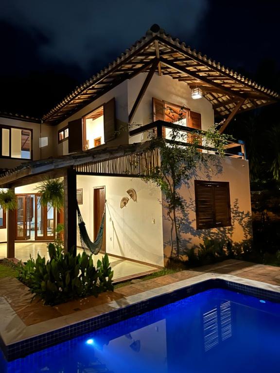 une maison avec une piscine devant dans l'établissement Pousada ViniCarmel Arraial d ajuda, à Arraial d'Ajuda