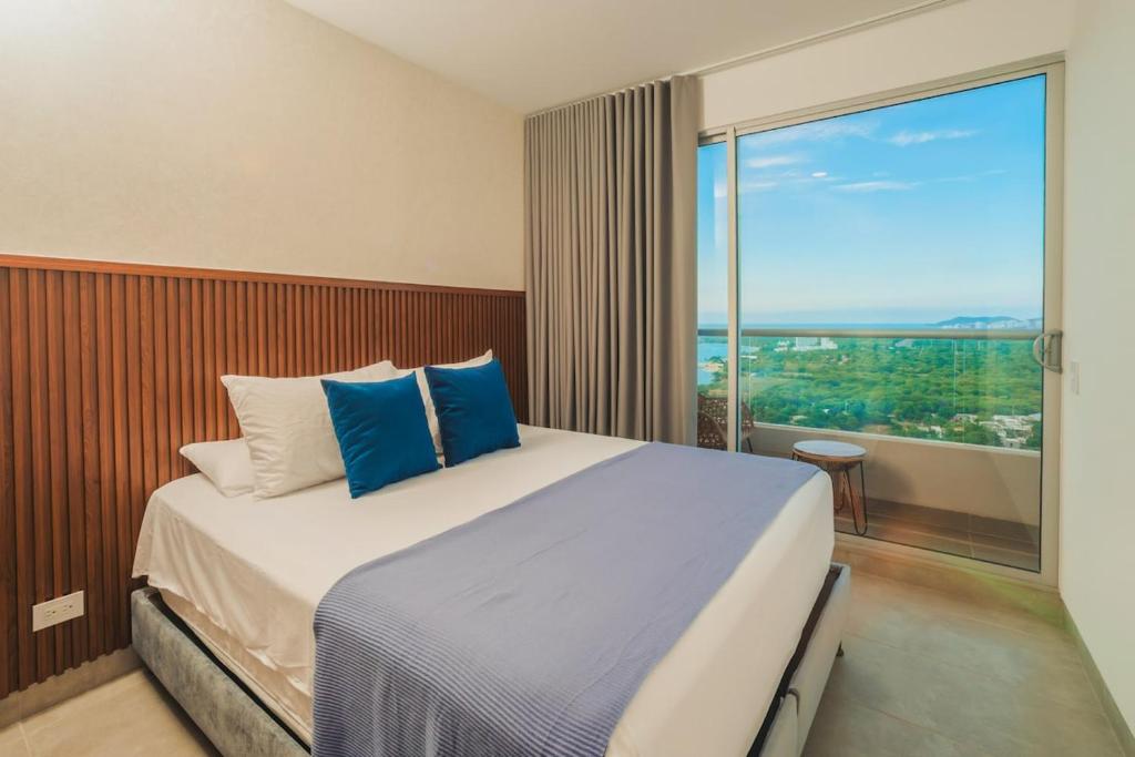 Apartment on the 21st floor, ocean and Sierra views في Simón Bolivar: غرفة نوم بسرير كبير مع نافذة كبيرة