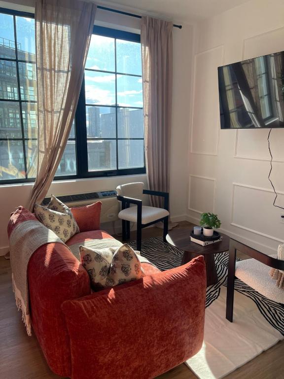 a living room with a couch and a table at Lux Bronx Apt Rooftop, Pool, Gym, Cinema in Mott Haven
