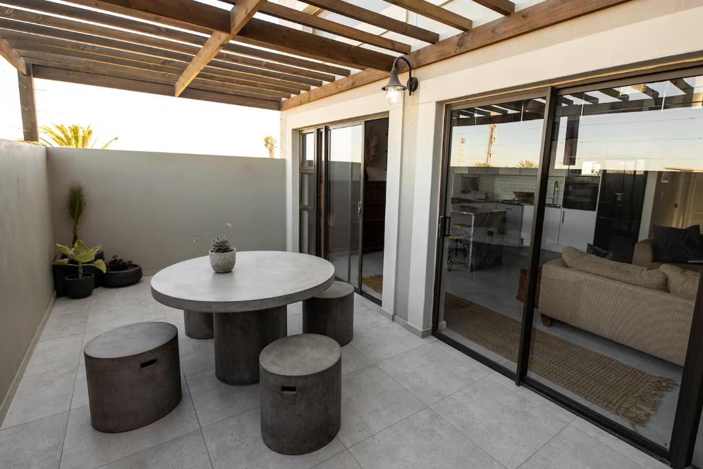 een terras met een tafel, krukken en een bank bij Cosmic Voyage in Nouakchott