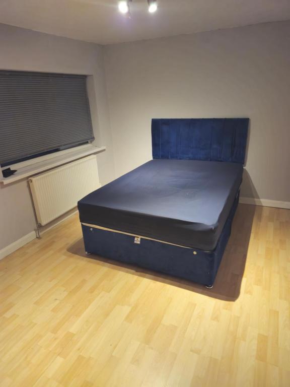 Una cama grande en una habitación con suelo de madera. en Constable Road, en Moffat