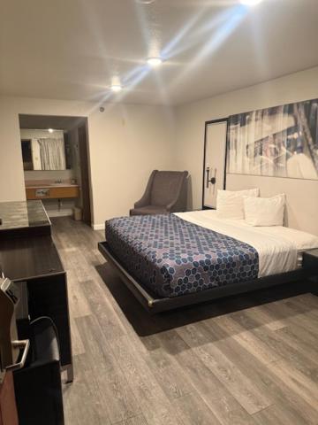 a bedroom with a bed and a chair in it at GO2 Inn & Suites by Relianse - El Paso in El Paso