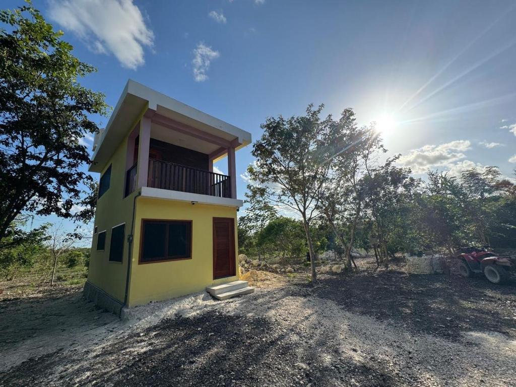 a small yellow house in the middle of a field at Casa en Huerto Frutal in Chicanna