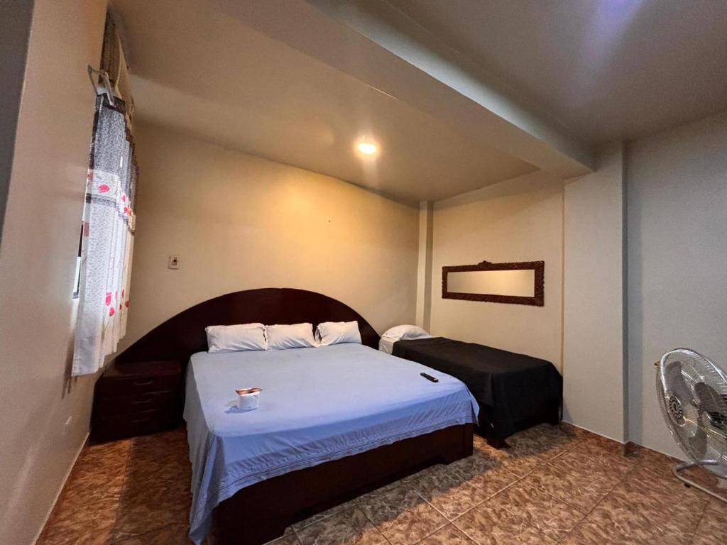 a small bedroom with a bed and a couch at Hotel Casa Luna in Iquitos