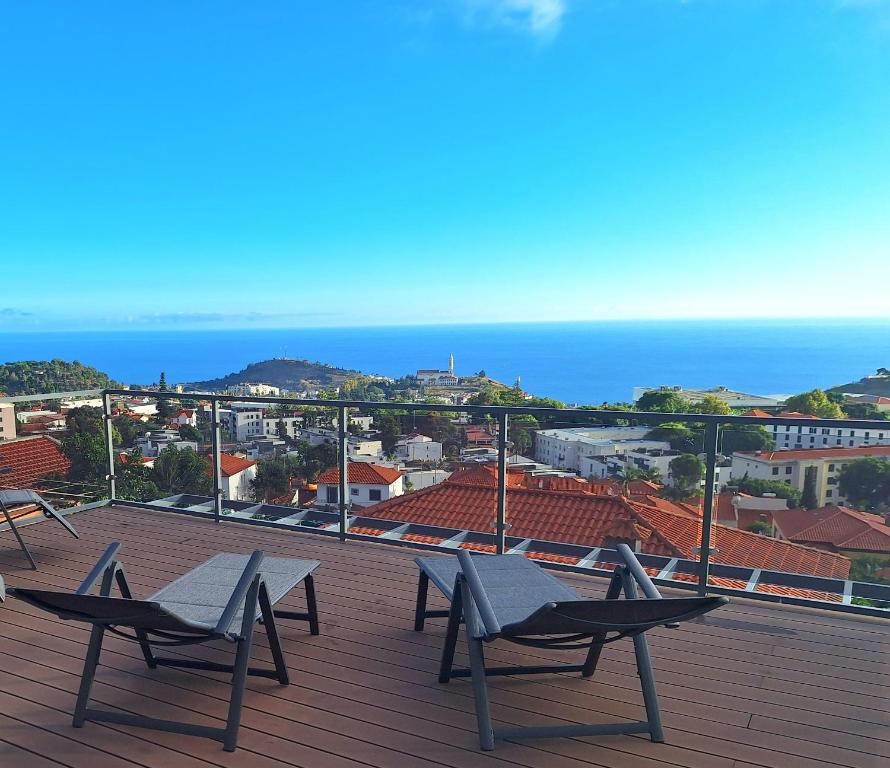 una terraza con 2 sillas y vistas al océano en Skyline Home Funchal, en Funchal