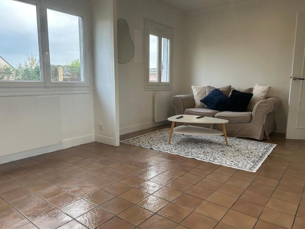 a living room with a couch and a coffee table at Maison chaleureuse à 2 minutes de la mer in Colleville-Montgomery
