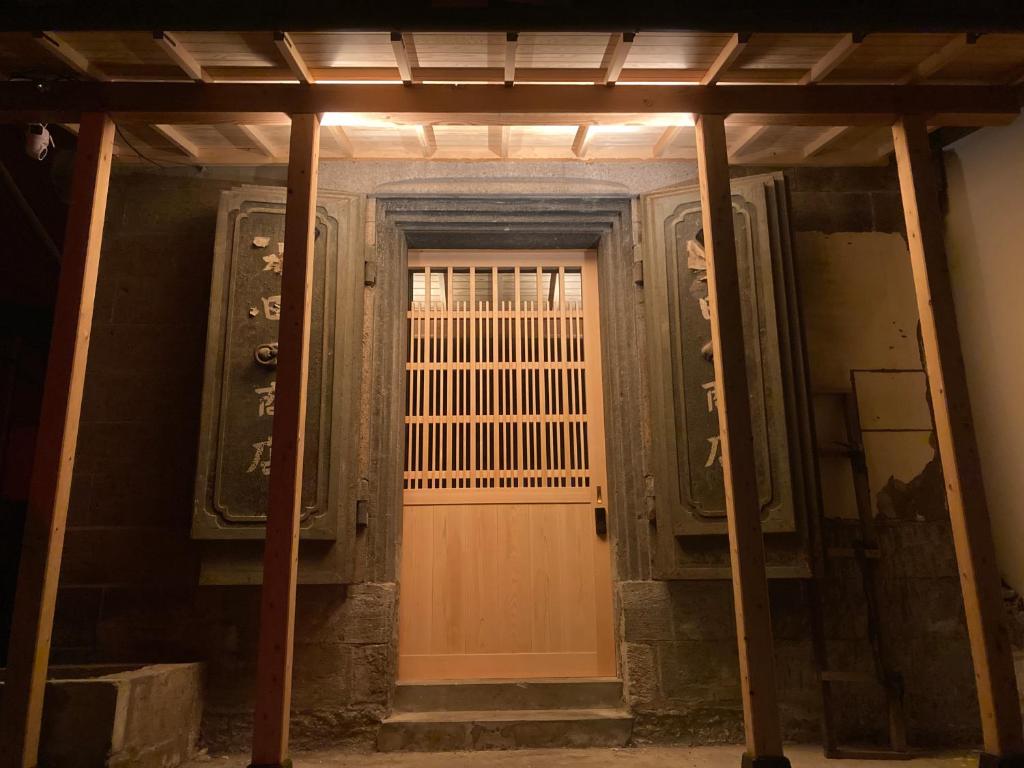 an entrance to a building with a wooden door at STAY local 石蔵 in Numazu