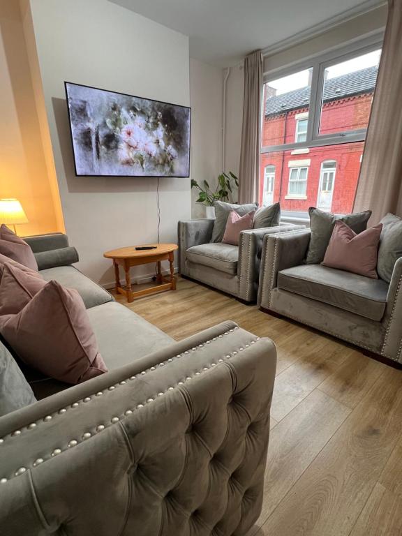 a living room with couches and a large window at Liverpool Rose House Stylish 3 Bed Near Anfield and Goodison Park in Liverpool