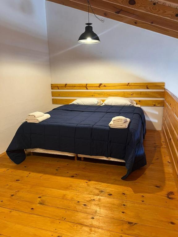 a bedroom with a blue bed with a wooden headboard at Chalten Mountain Loft 6 in El Chalten