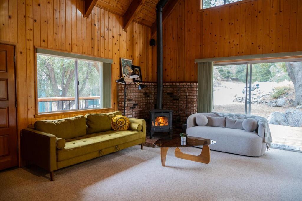 ein Wohnzimmer mit Sofa und Kamin in der Unterkunft Sunshine Cabin Cozy 3BR Getaway and Deck in Pine Mountain Club