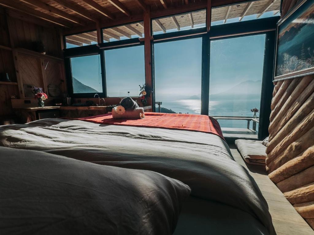 a bedroom with a bed with a large window at Lake Atitlán Panorama Chalets in San Marcos La Laguna
