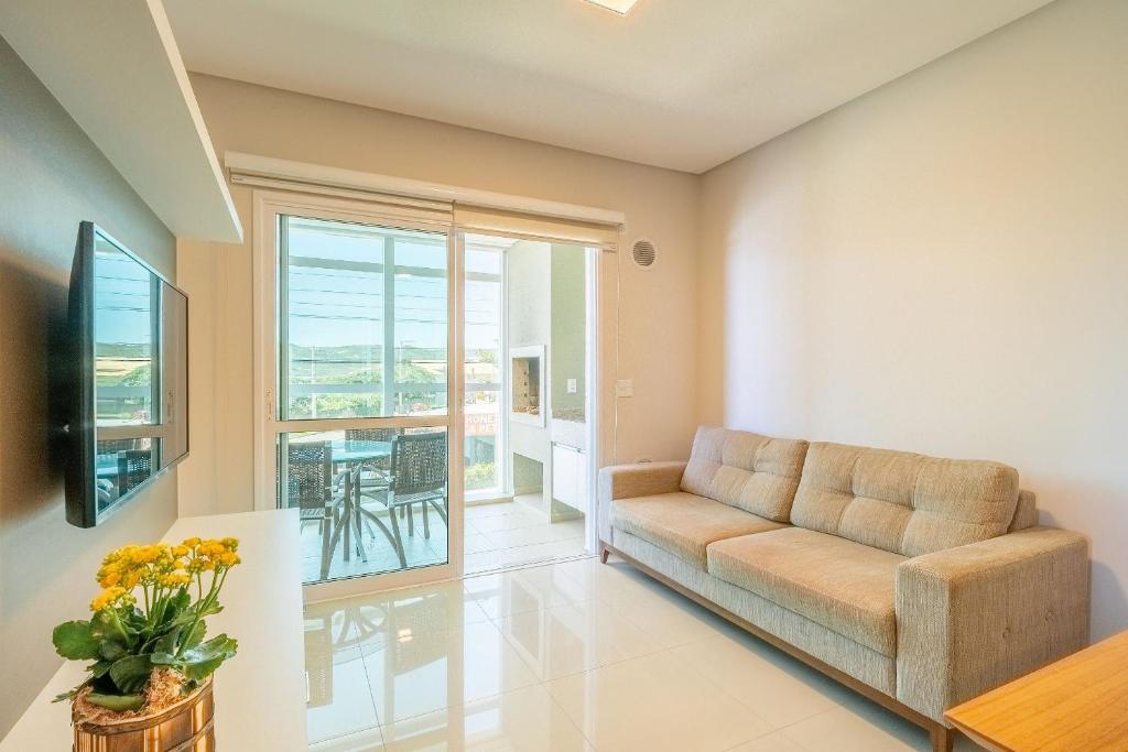 a living room with a couch and a table at Apartamento vista para o mar com 02 dormitórios in Canto Grande