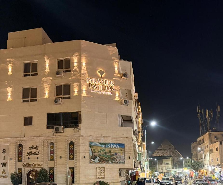 Un edificio con un cartel al costado. en Pyramids Pavilion Boutique Hotel, en El Cairo
