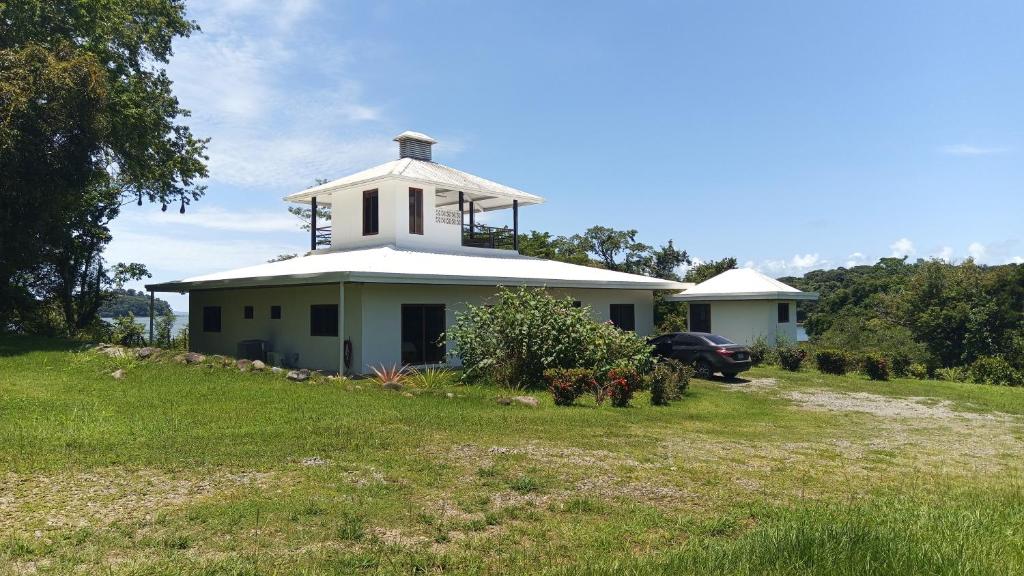 une maison blanche avec une tour au sommet d'un champ dans l'établissement Fishon Panama Lodge, à Boca Chica