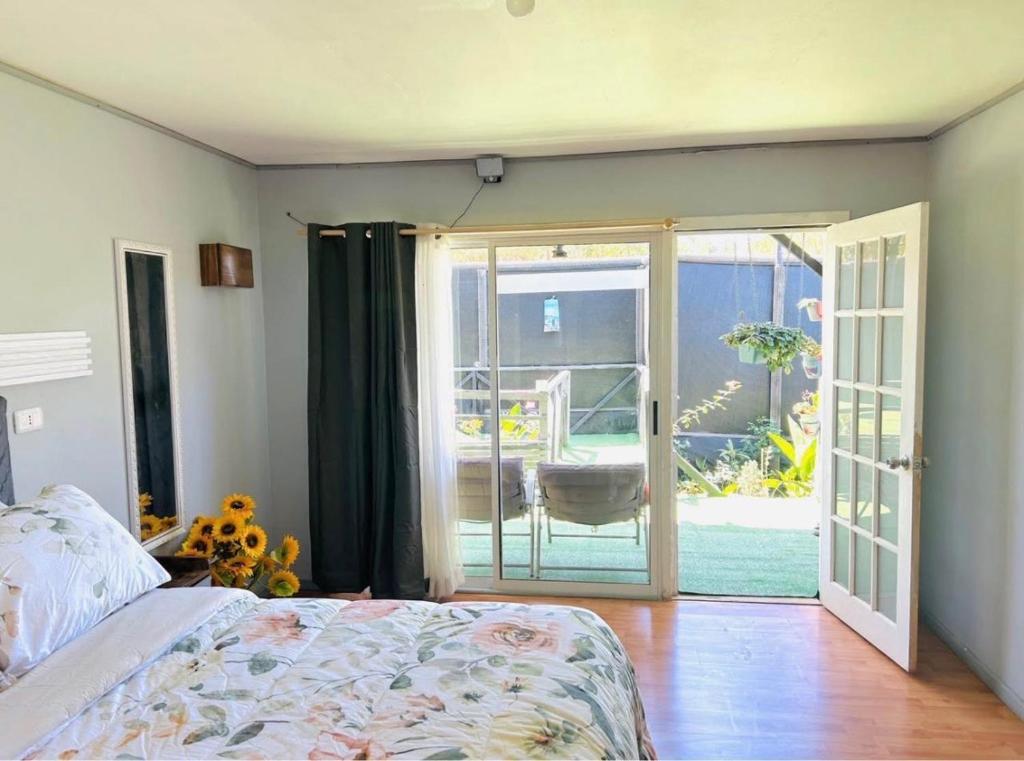 a bedroom with a bed and a sliding glass door at Mini Regugio in Chillán