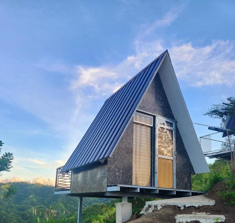 a house with a blue roof and a window at MIRA AgroPark in Kuyambay