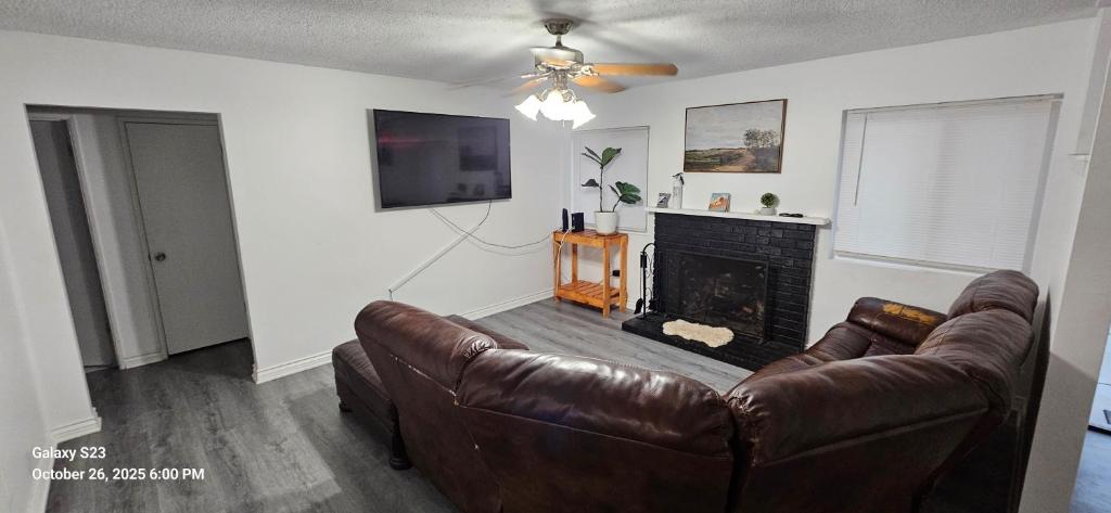 a living room with a leather couch and a fireplace at Lovely Rural Living in Cherry Valley