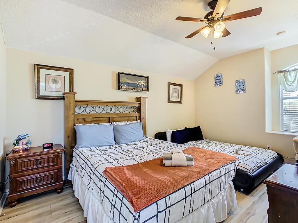 une chambre avec un lit et un ventilateur de plafond dans l'établissement Spacious Villa W Pool, Spa & Game Room, à Orlando