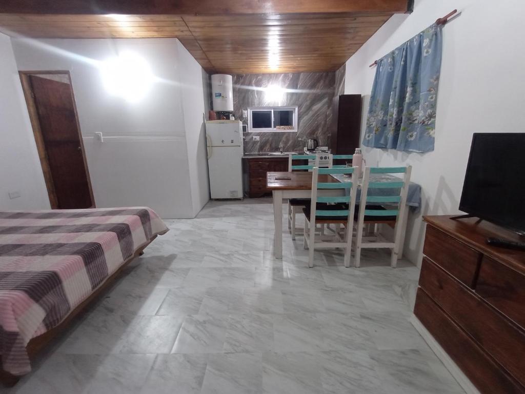 ein Schlafzimmer mit Bett und Tisch und eine Küche in der Unterkunft El monito de Sanber in San Bernardo