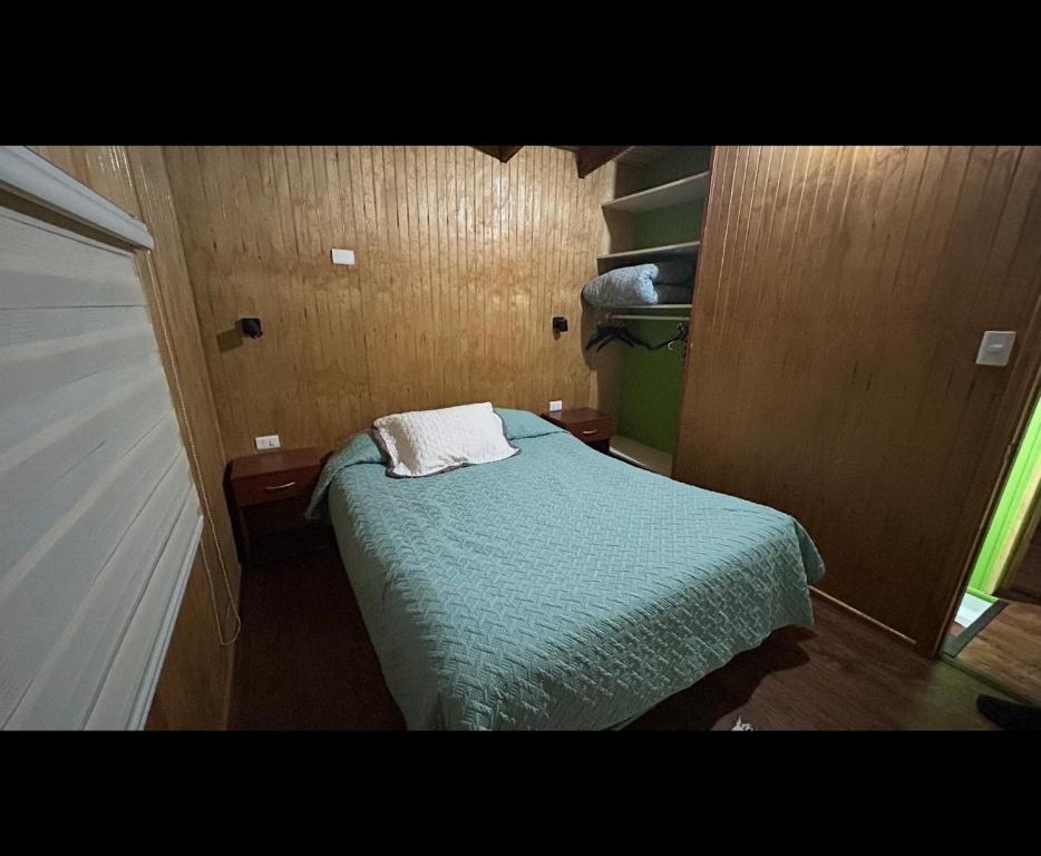 Un pequeño dormitorio con una cama con una toalla. en Casa a Mano todo cercano, en Futrono