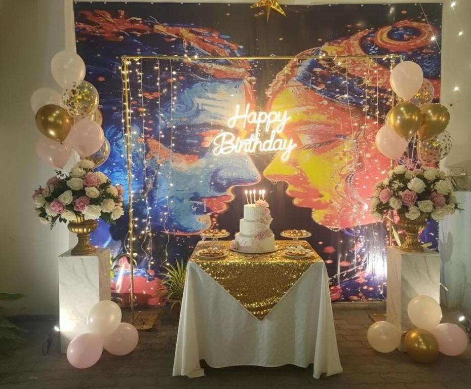 einen Tisch mit einem Kuchen und ein Happy Birthday-Schild in der Unterkunft The Moksha Residency By MOM'S in Prayagraj