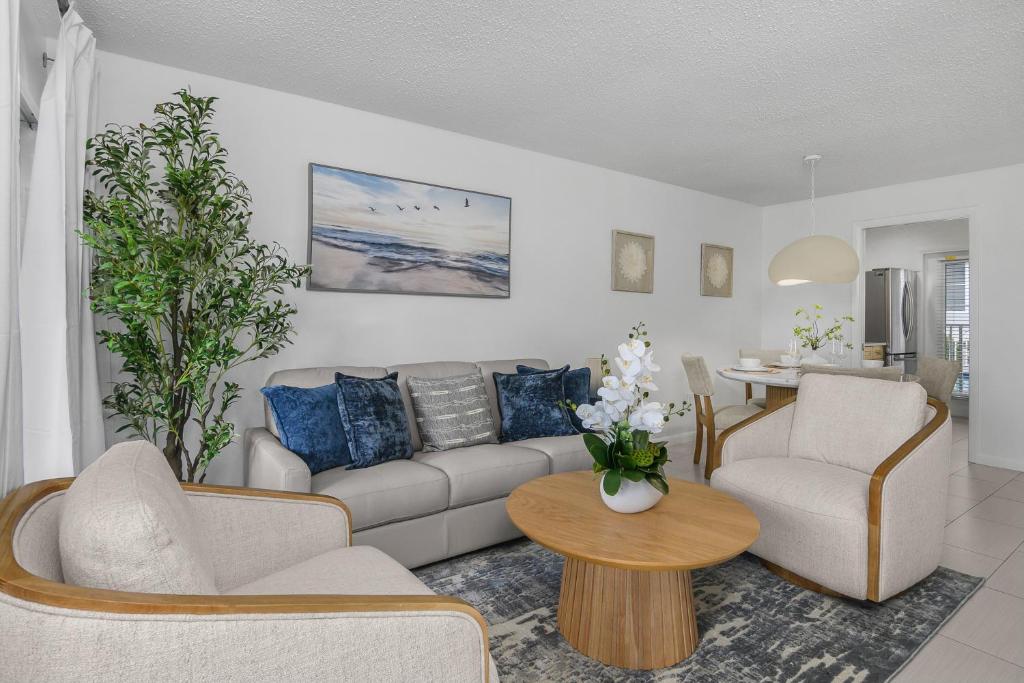 a living room with a couch and chairs and a table at The Naples Beach Retreat in Naples
