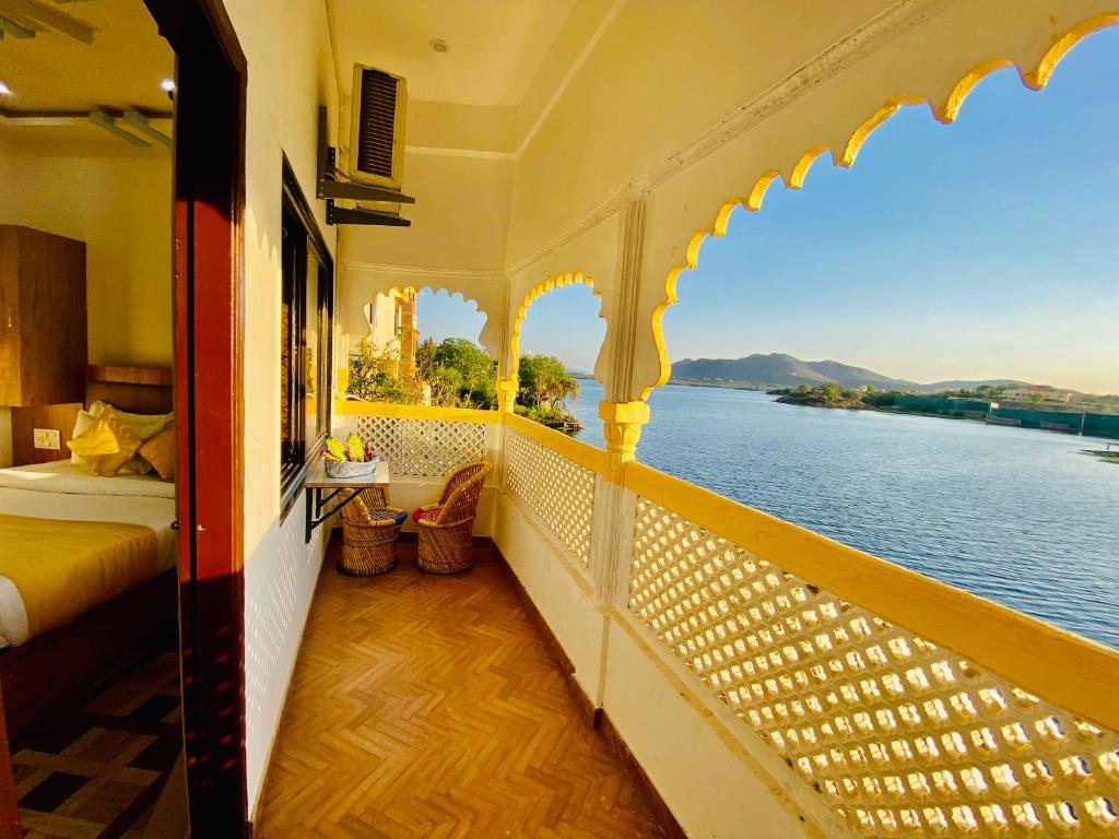 a balcony of a hotel with a view of the water at Hotel Vallabh at Pichola Lake Nathi Ghat Brahmpole Udaipur in Udaipur