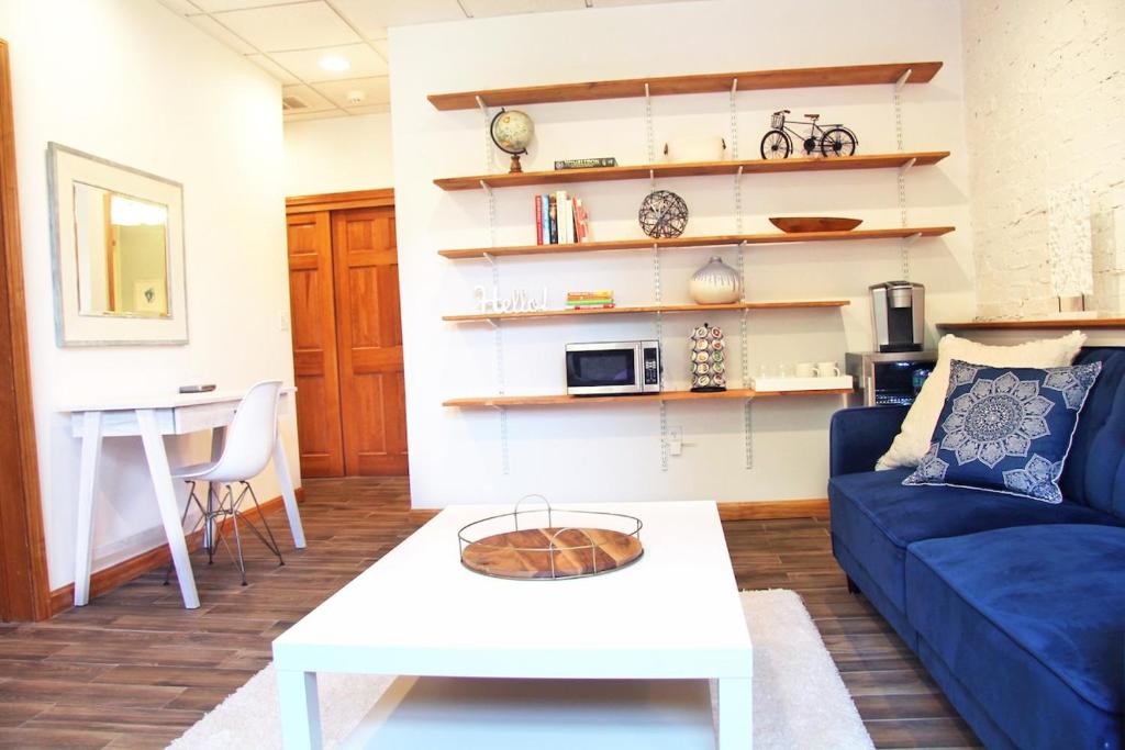 a living room with a blue couch and a table at Brighton guest suite in Boston