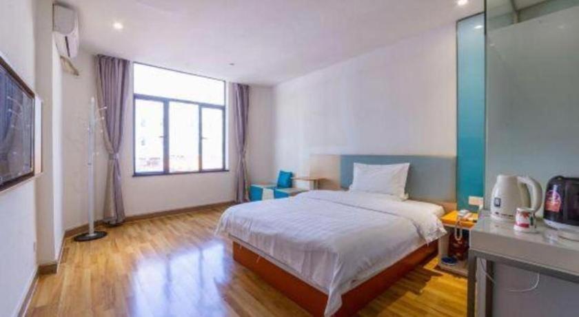 ein Schlafzimmer mit einem Bett und einem großen Fenster in der Unterkunft 7 Days Inn Huizhou Danshui Yi Center in Huizhou