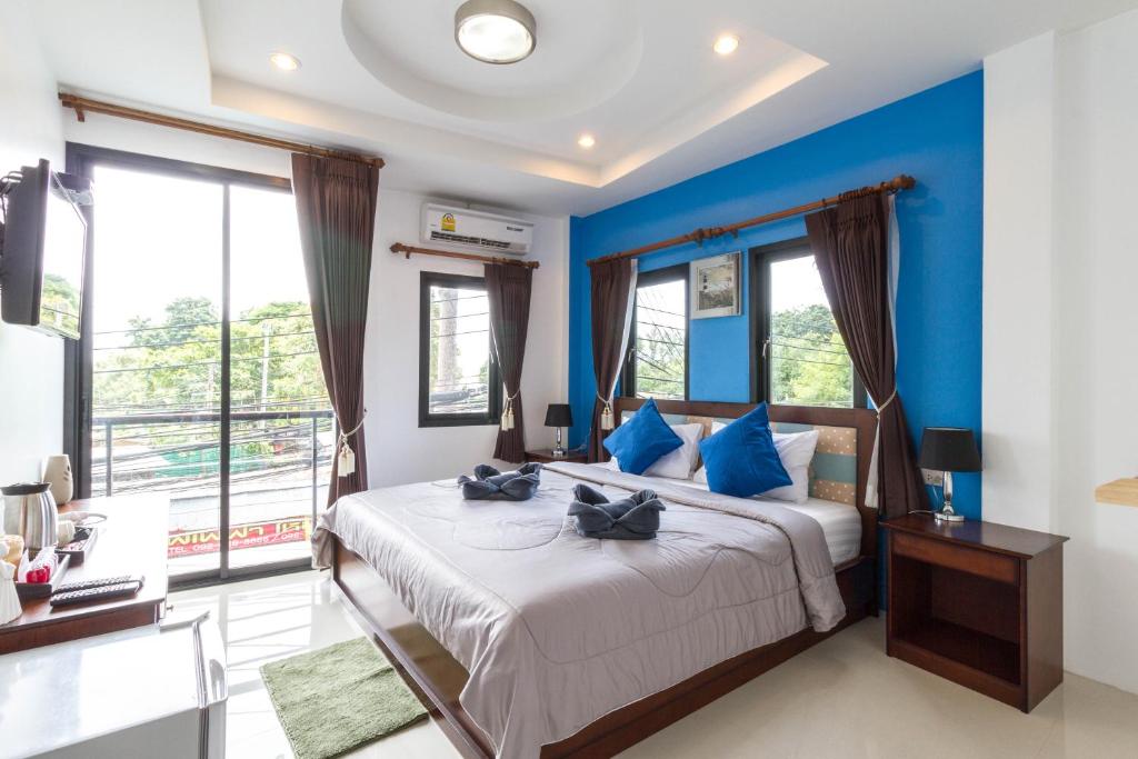 Schlafzimmer mit blauen Wänden und einem Bett mit blauen Kissen in der Unterkunft Samed Big Tree in Ko Samed