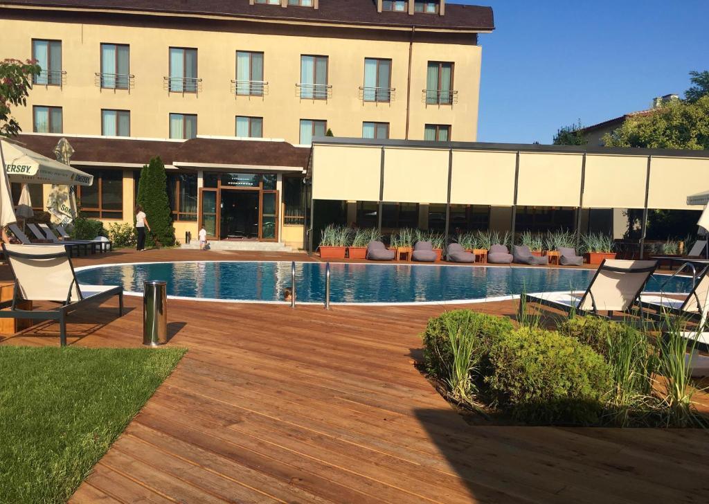 un complexe avec une piscine, des chaises et un bâtiment dans l'établissement Hotel Perperikon, à Kardjali