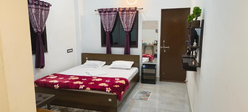 a bedroom with a bed with a red blanket at Hotel Purvanchal in Katihār