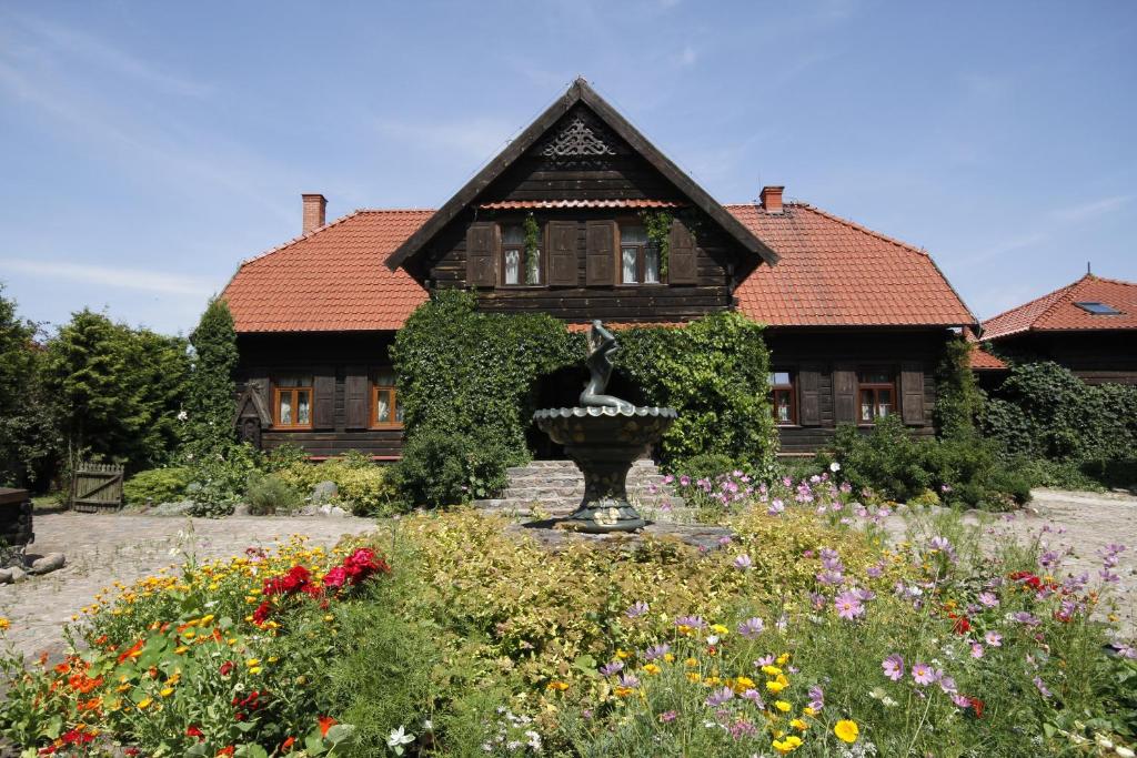 una casa con una fuente en medio de un jardín en Kiermusy Dworek nad Łąkami, en Kiermusy