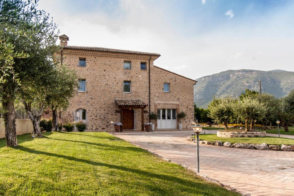 ein großes Steingebäude mit einem Rasenplatz davor in der Unterkunft Aia Antica in Monte San Biagio