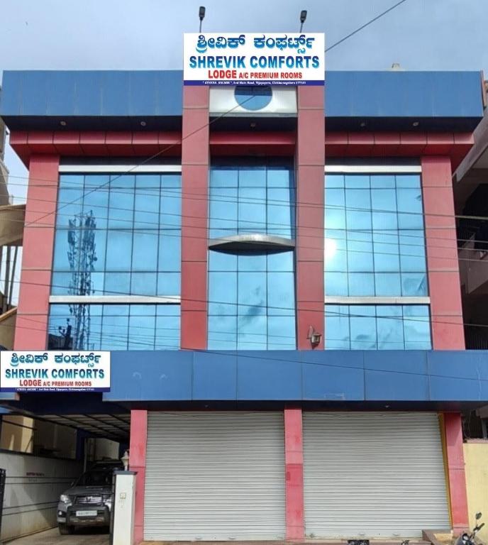 a building with a sign for a shopping center at SHREVIK Comforts in Chikmagalūr