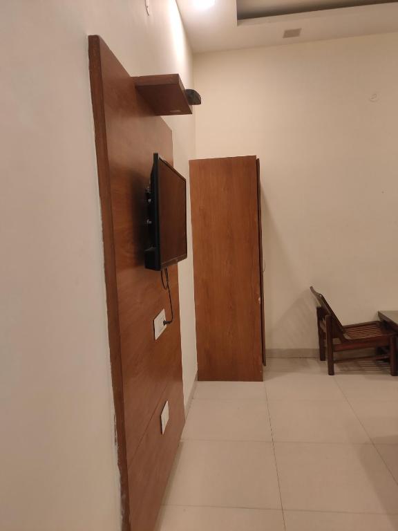 a room with a door with a television on the wall at Love kush hospitalitie in Ujjain