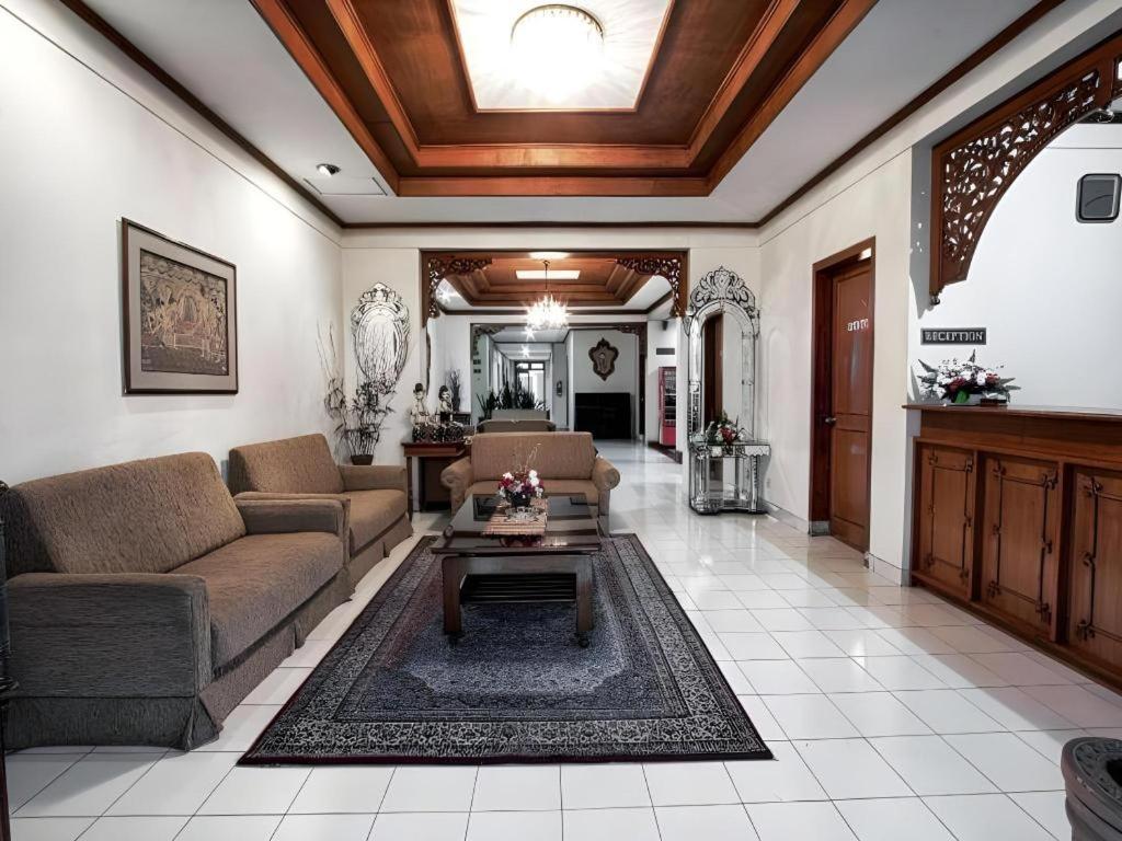 ein Wohnzimmer mit Sofa und Tisch in der Unterkunft Hotel Griyadi Kusuma Sahid in Solo