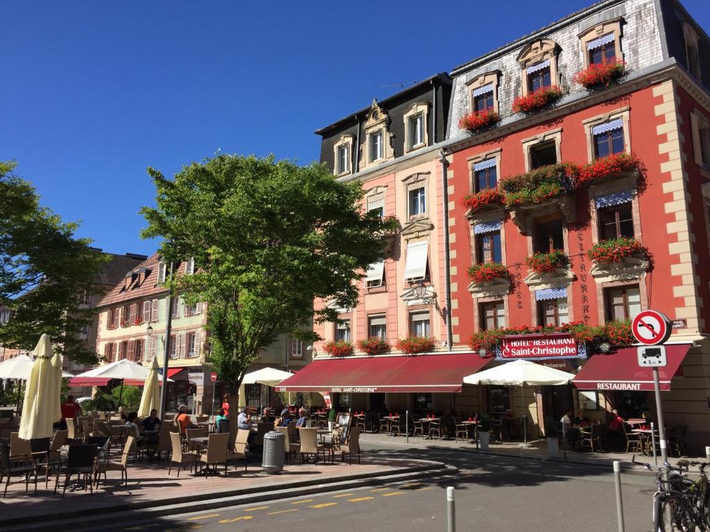 eine Straße mit Tischen und Stühlen vor den Gebäuden in der Unterkunft Hotel-Restaurant St-Christophe in Belfort