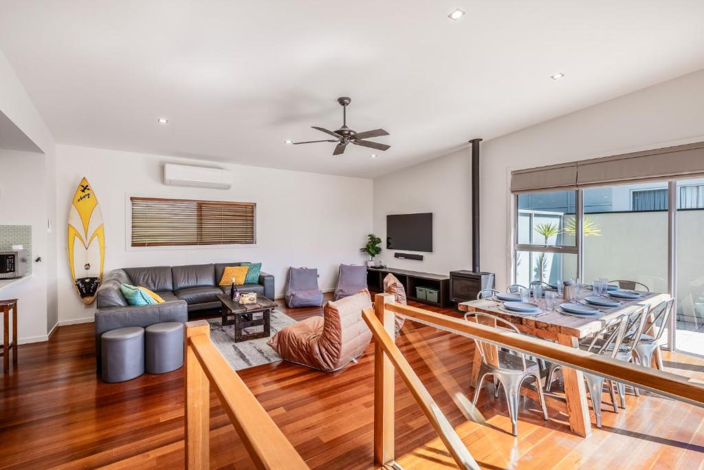 a living room with a couch and a table at Coastal Comfort, Just a Ocean Glimpse Away Torquay in Torquay