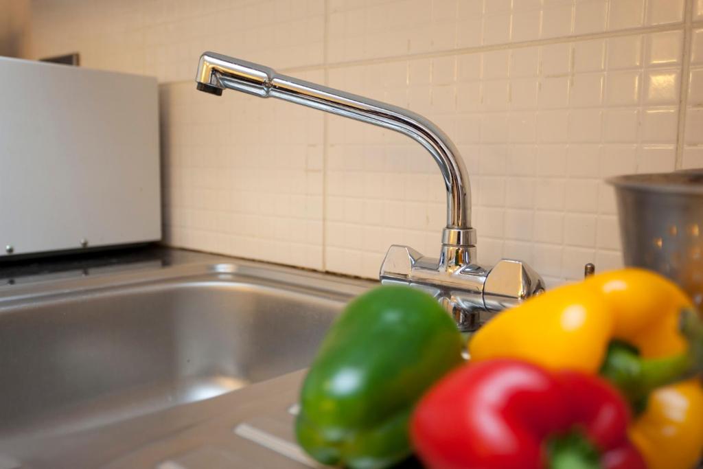 a kitchen sink with a faucet and some peppers at City Central Apartments - above Victoria Centre Shopping Centre - most Central Location on Milton Street next to the Hilton Hotel - Apartments with up to 4 Beds - Cook as you would at Home - Outdoor Parking for Cars or Vans at five pounds a day in Nottingham