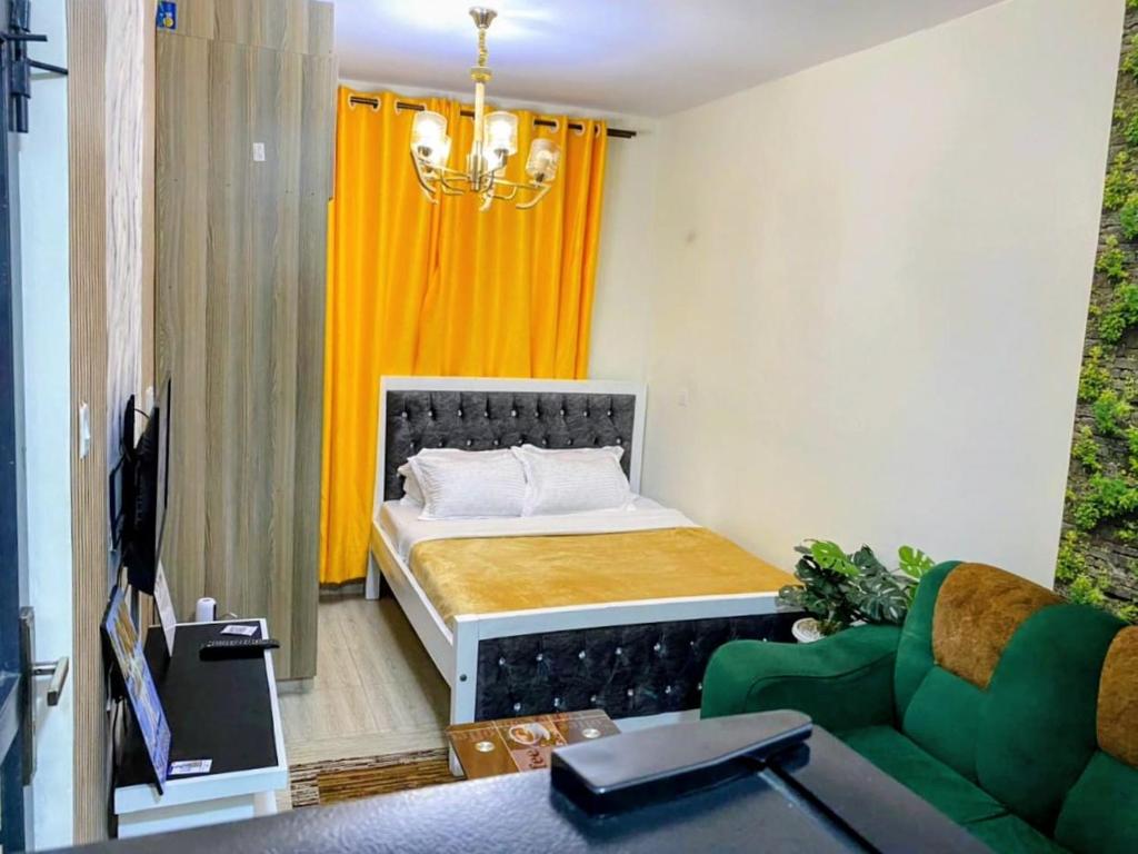 a bedroom with a bed and a green couch at Gnittel haven in Nairobi