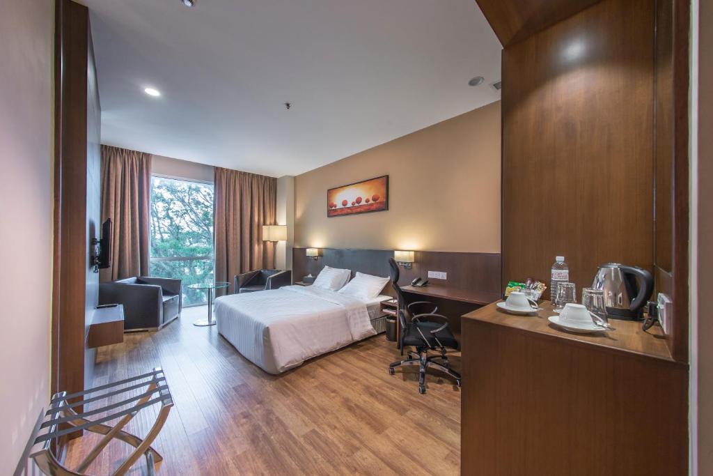 Cette chambre comprend un lit et un bureau. dans l'établissement Keoja Hotel, à Kuala Belait
