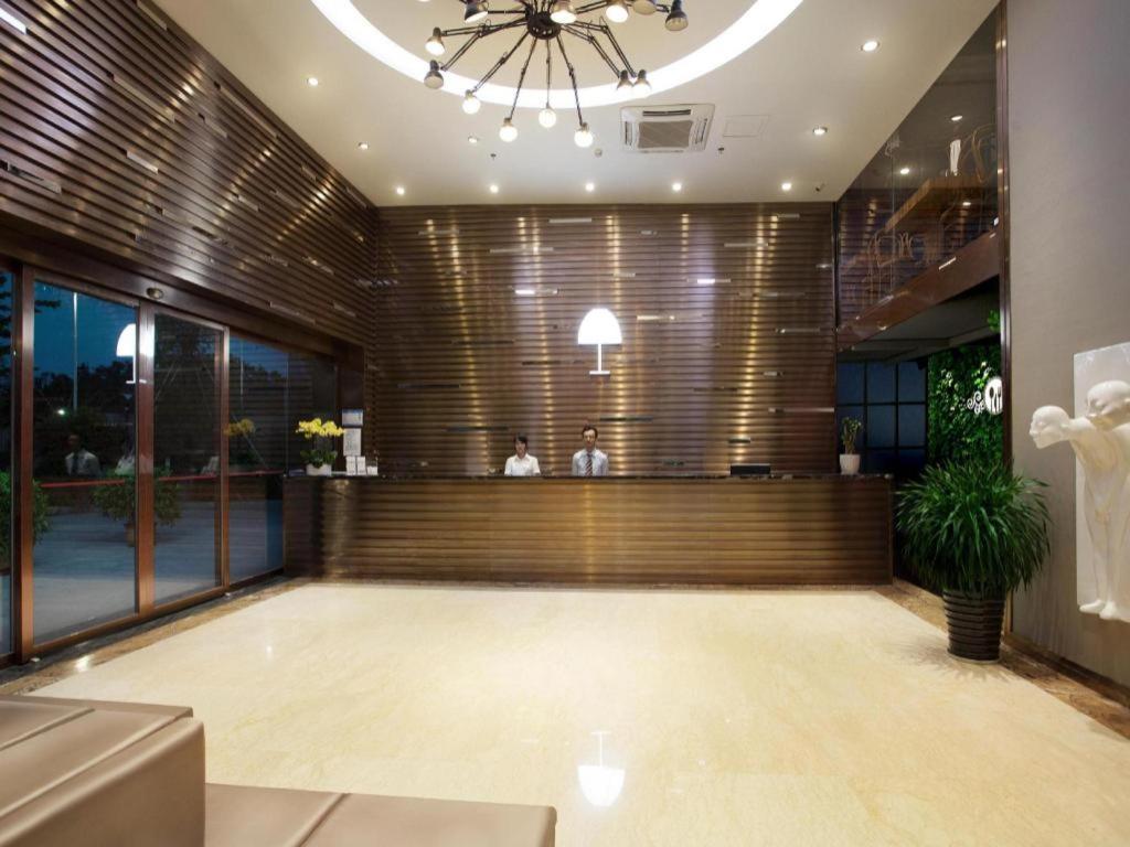 a lobby with a bar with two people in the background at The Art Hotel in Shenzhen