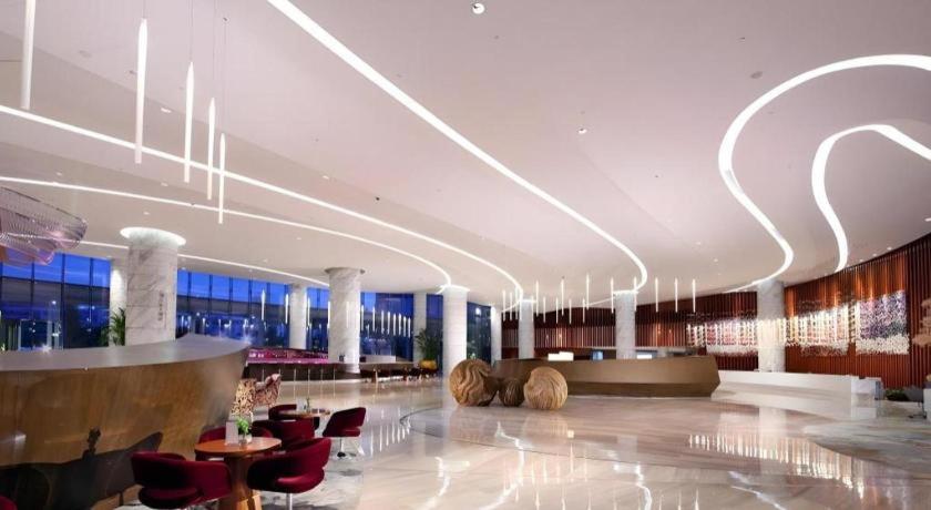 a lobby of a building with tables and chairs at Fliport Hotel Zhangzhou Yuanshan in Zhangzhou