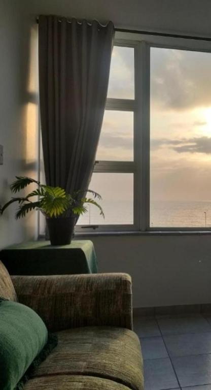 a living room with a couch and a large window at Peacehaven's Finest View 107 in Scottburgh