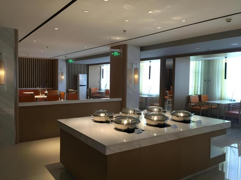 una cocina con muchas ollas y sartenes en una estufa en Jinjiang Inn Handan Zhonghua Nan Street Xueyuan Bei Road, en Handan