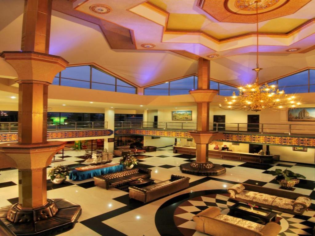 a large lobby with couches and a chandelier at Yusro Hotel Restaurant & Convention in Peterongan