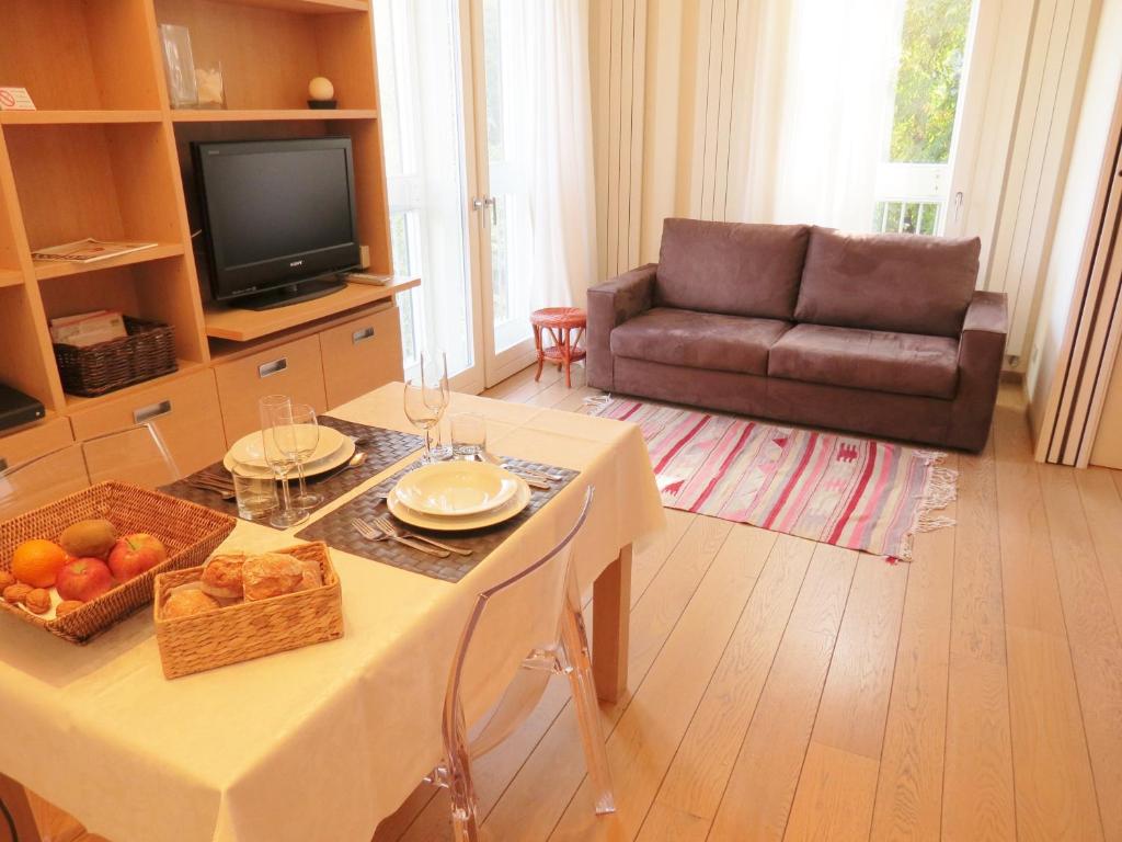 sala de estar con mesa y sofá en Belisario Fiera Milano Apartment, en Milán