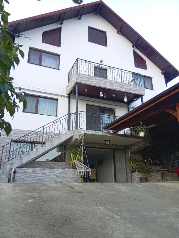 a white building with stairs and a balcony at Casa RiAn in Drăgăneasa
