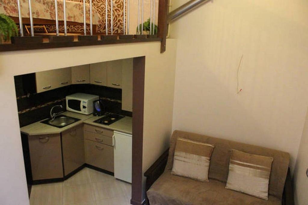 een kleine keuken met een bank en een magnetron bij Ohiienka Apartment in Lviv